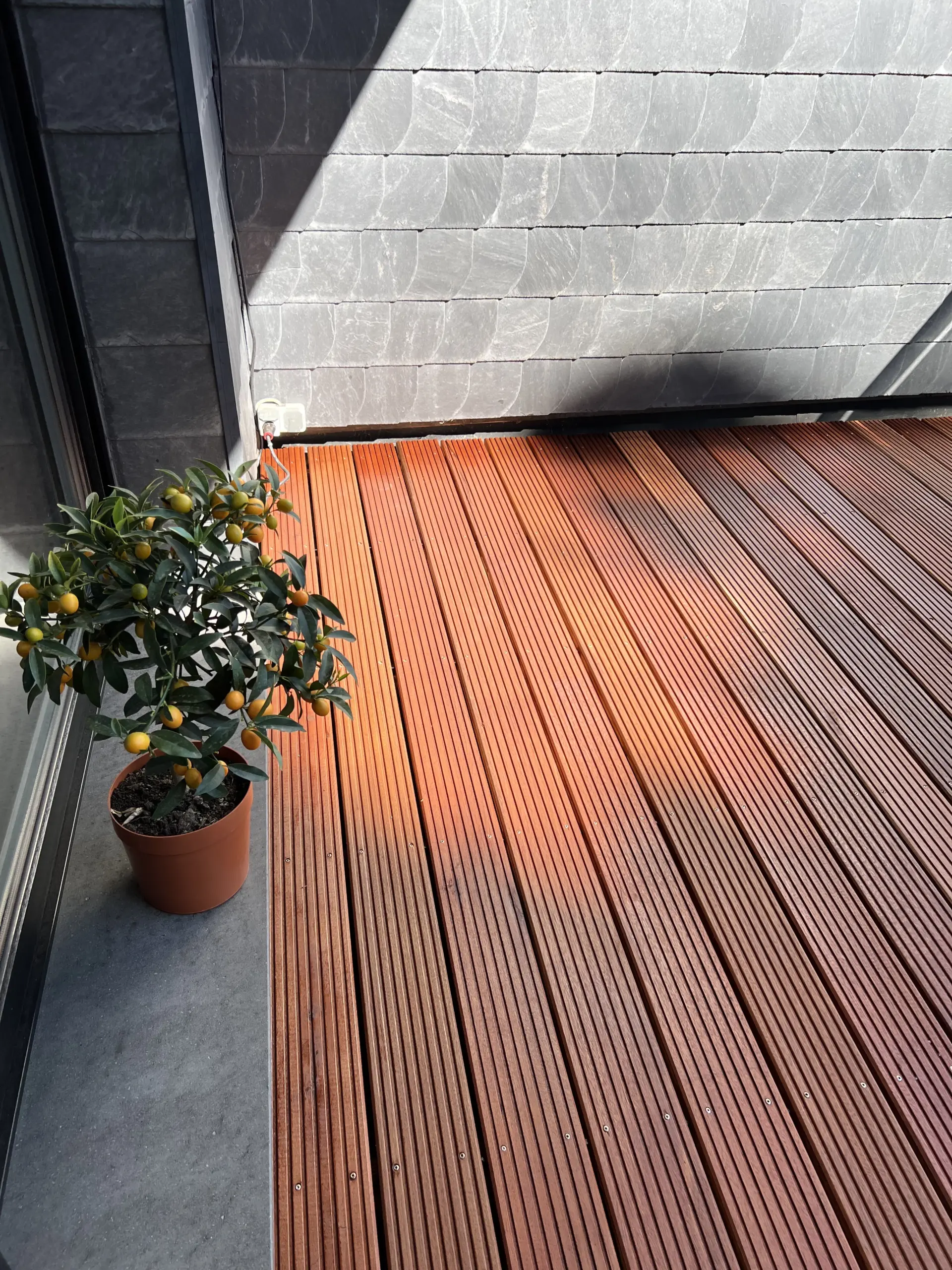 Fertig verlegte, geölte Bangkirai-Terrasse auf einem großen Balkon.