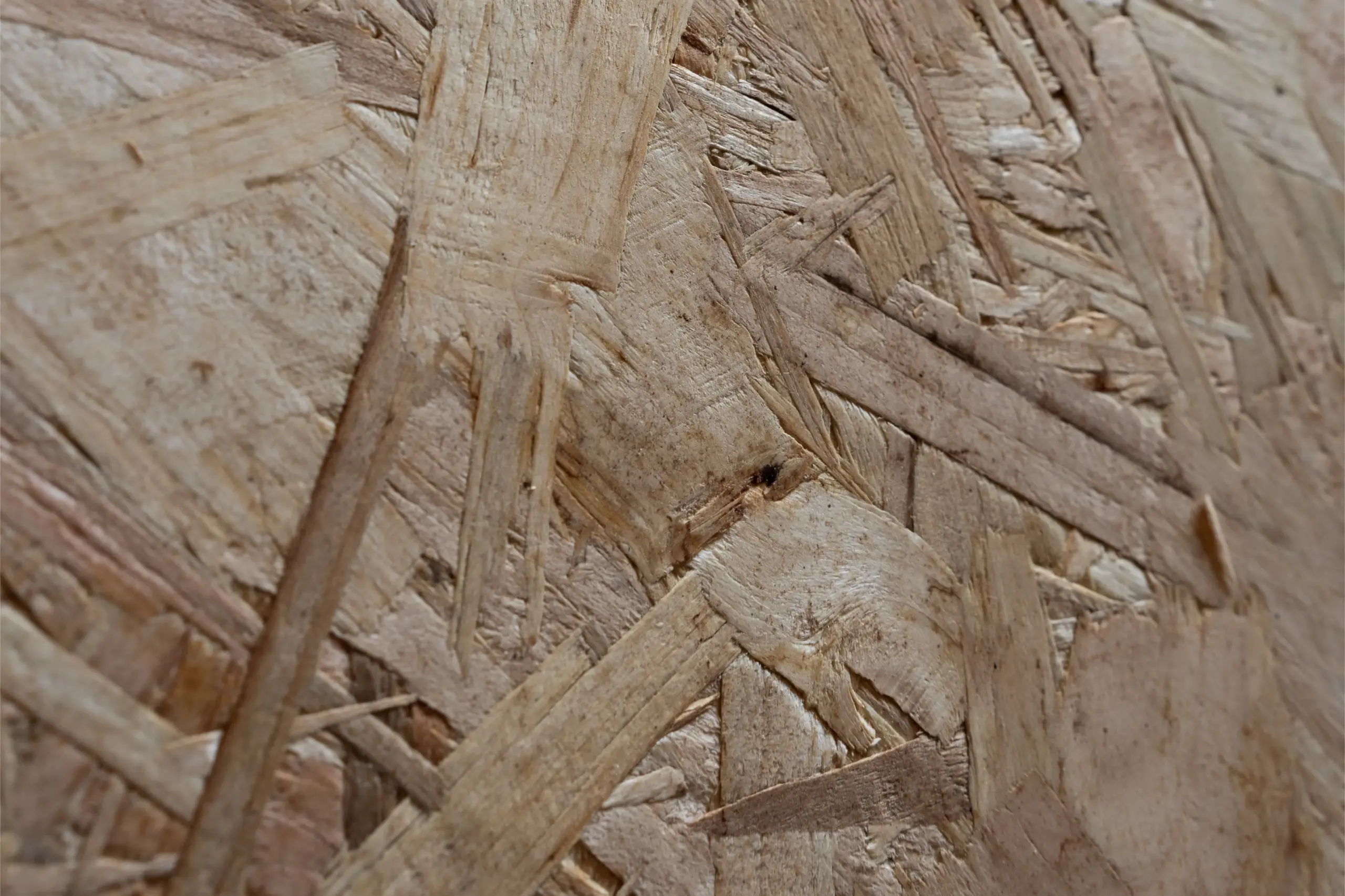Nahaufnahme einer OSB-Platte mit sichtbarer Holzstruktur und Spänen.
