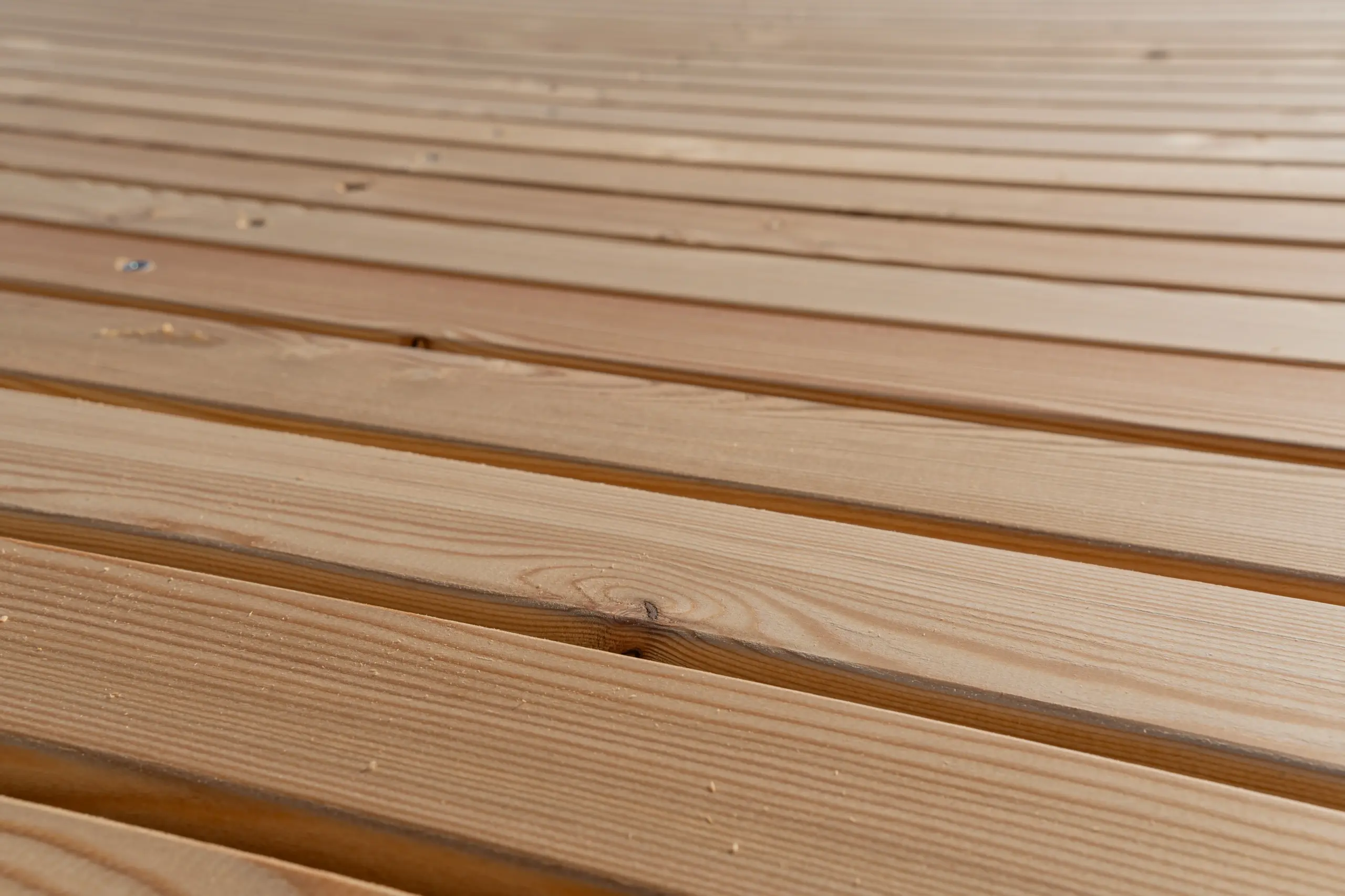 Rhombusleisten-Zaun aus sibirischer Lärche – Bauprozess in Nahaufnahme Nahaufnahme eines Rhombusleisten-Zauns aus sibirischer Lärche während des Bauprozesses.