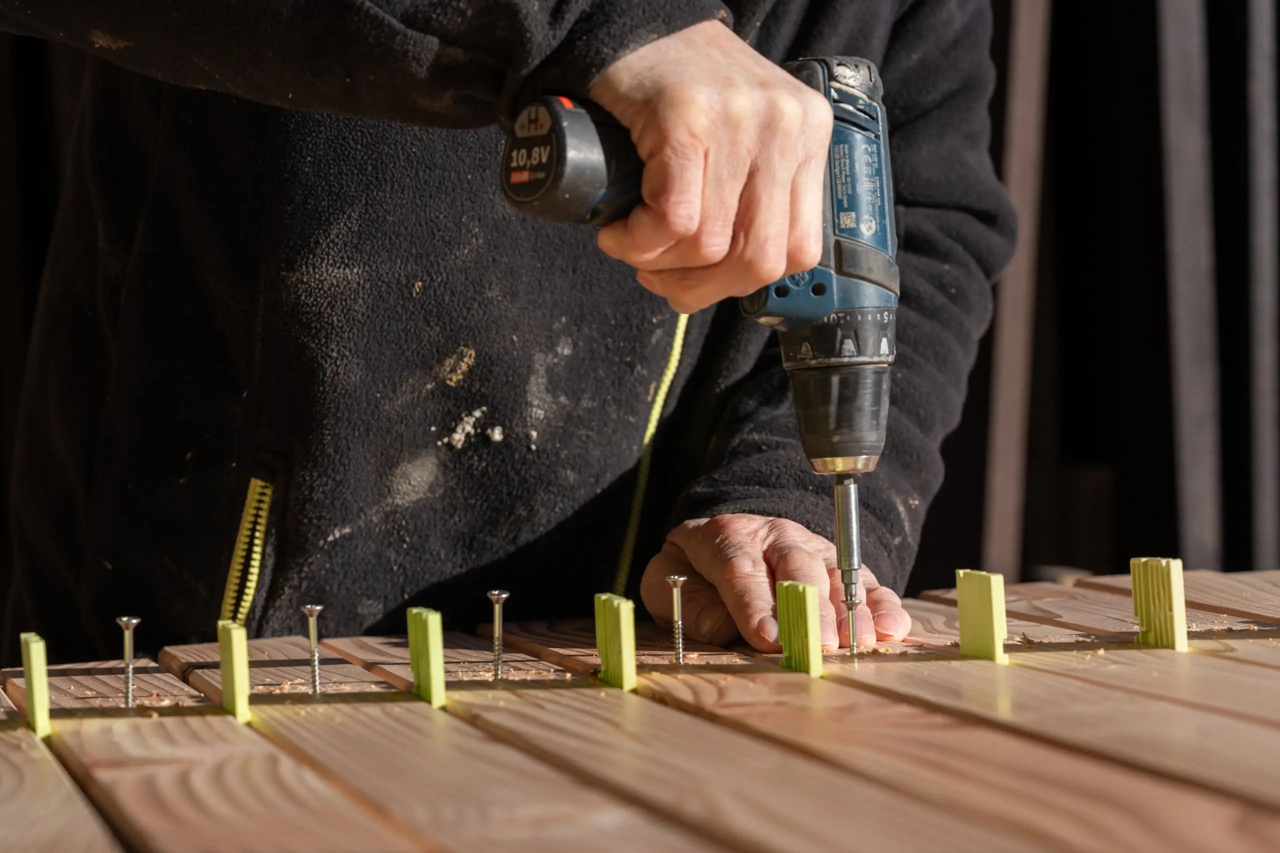 Rhombusleisten-Zaun aus sibirischer Lärche – Bauprozess in Nahaufnahme Nahaufnahme eines Rhombusleisten-Zauns aus sibirischer Lärche während des Bauprozesses.