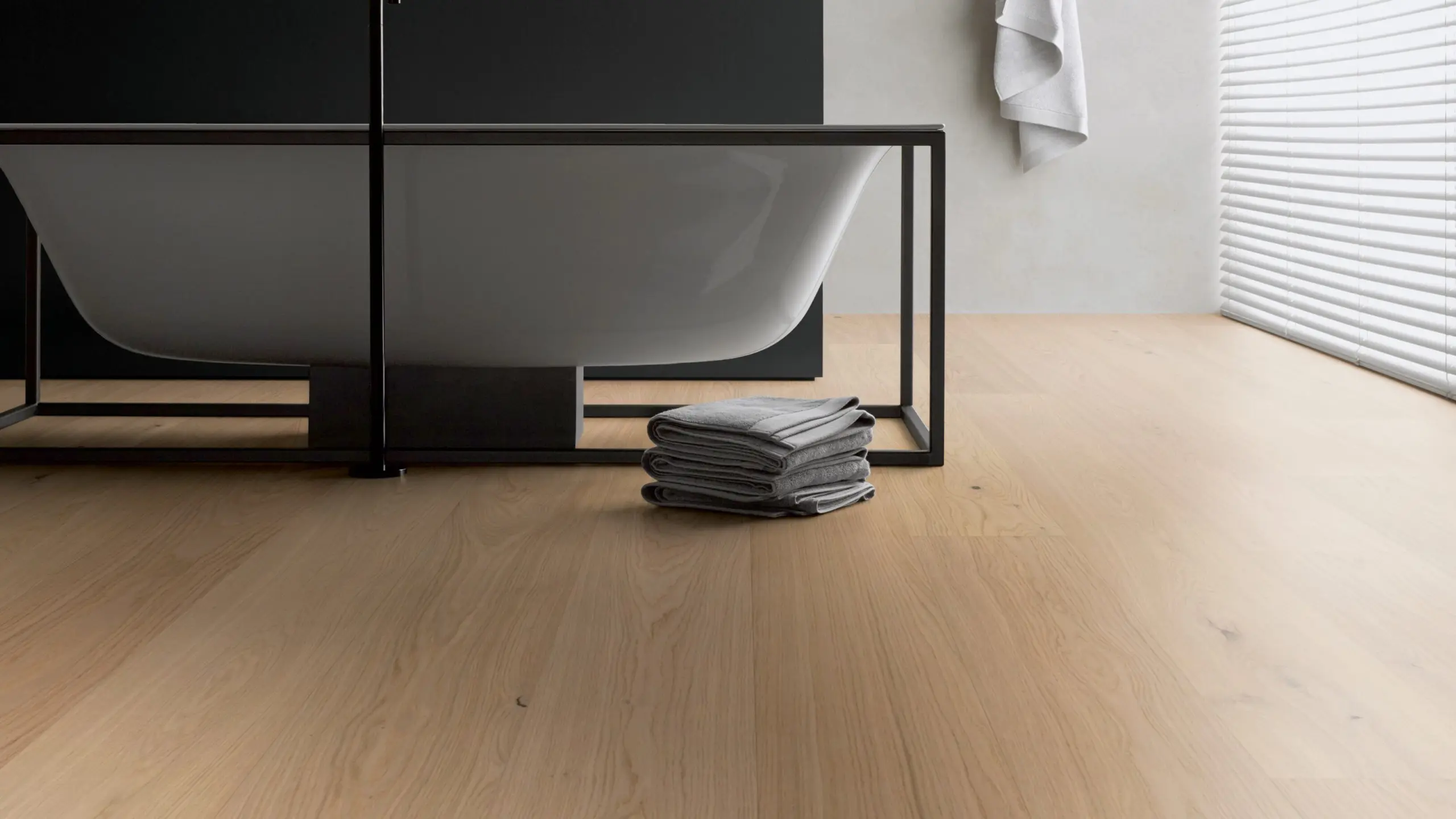 Helles Badezimmer mit einer freistehenden Badewanne auf einem robusten Echtholz-Hybridboden in Eiche von Hywood